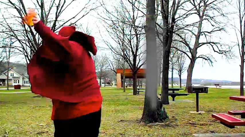 A person throwing a fireball at another person hiding behind a tree.