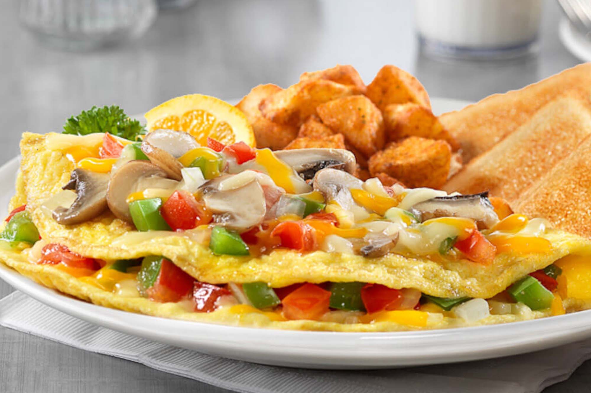 picture of an omellette with peppers, mushrooms and cheese.